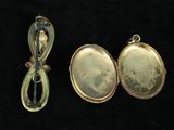 two gold lockes and a silver spoon on a black background