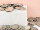 a pile of coins sitting on top of a marble block