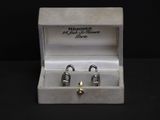 two pairs of earrings in a white box with a black background