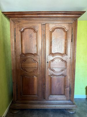une armoire en bois dans une pièce aux murs verts