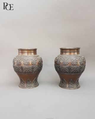 two silver vases sitting next to each other on a table