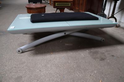 une table basse en verre sur laquelle est posé un coussin noir