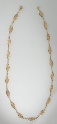 a gold necklace on a white background