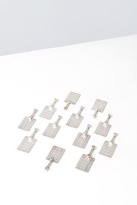 several pieces of metal are arranged in a square pattern on a white surface
