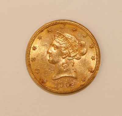a close up of a gold coin on a white surface