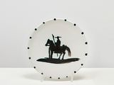 une assiette en noir et blanc représentant la silhouette d'un homme à cheval