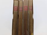 trois livres sont empilés sur une surface blanche
