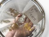 a person holding a glass jar with a label on it