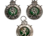 trois insignes argentés et verts représentant un lion sur fond blanc