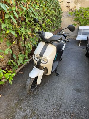 un scooter garé à côté d'un banc