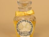 une petite bouteille en verre ornée d'un nœud jaune