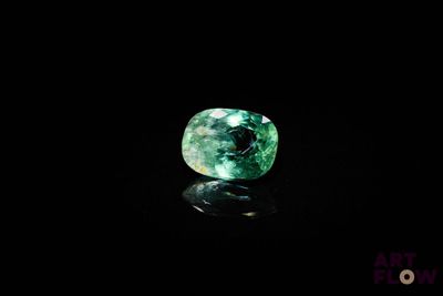 un gros plan d'une émeraude verte sur une surface noire