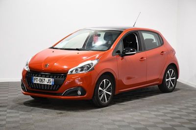 une voiture rouge est garée dans une pièce au sol en damier