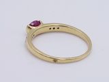 a close up of a gold ring with a ruby stone
