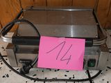 a toaster on the floor with a pink sticker on it