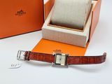 an orange box with a watch inside of it next to an orange box