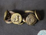 some old buttons are sitting on a table with a coin