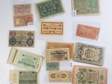 several different types of paper money sitting on top of a white surface
