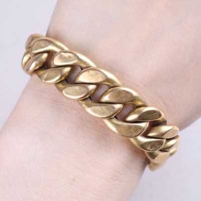 a close up of a person ' s hand wearing a gold bracelet