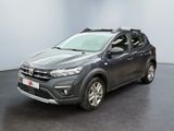 La Toyota RAV grise est garée dans une pièce au sol noir.