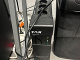 a black speaker sitting next to a black speaker on a stand