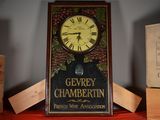 une horloge posée sur une étagère à côté de quelques cartons