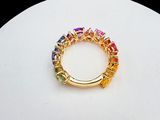 an image of a gold ring with multi colored stones on a white surface