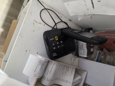 une télécommande noire posée sur une pile de papiers