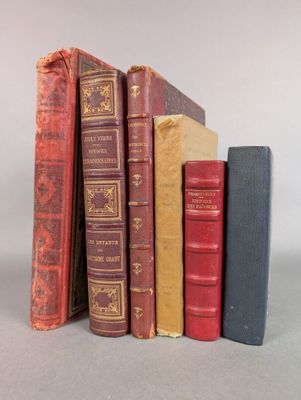 several old books are stacked on top of each other on a table