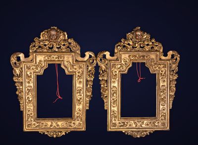 une paire de cadres photo anciens dorés sur fond bleu foncé