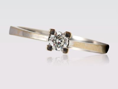 gros plan d'une bague en diamant sur une surface blanche