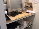 a computer and printer on a desk in a small room
