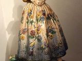 une photo représentant une figurine de femme en robe posée sur une table