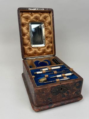 une petite boîte en bois contenant un miroir et une paire de ciseaux
