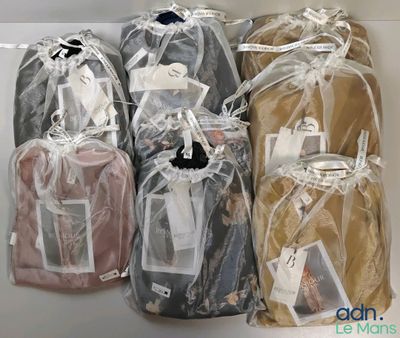 four bags of clothing wrapped in plastic on a shelf