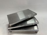 three metal trays stacked on top of each other on a white surface