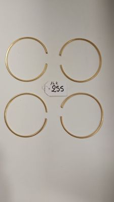 quatre bagues en or sur fond blanc, accompagnées d'une étiquette de prix