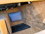 the interior of a car with the floor covered in tan carpet
