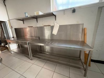 une grande cuisine en inox équipée d'un évier et d'une cuisinière