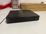 un lecteur DVD noir posé sur une table à côté d'une boîte
