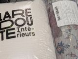many rolls of fabric sitting on the floor in a store