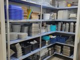 many plates and pans on the shelves in the kitchen