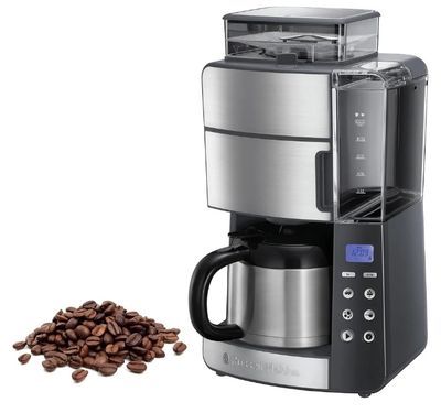 un gros plan d'une cafetière à côté d'un tas de grains de café