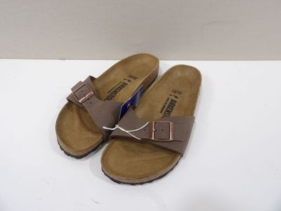 sandales Birkett marron avec des boucles, posées sur un fond blanc
