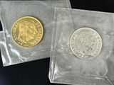 two coins are in a clear plastic bag on a black surface