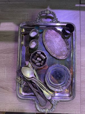 a silver tray with silverware and spoons on it