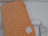 an orange blanket and a charger sitting on a table