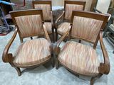 quatre chaises en bois avec des assises rembourrées à rayures dans une pièce