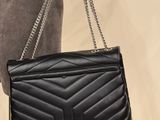 a woman holding a black handbag with a chain on it