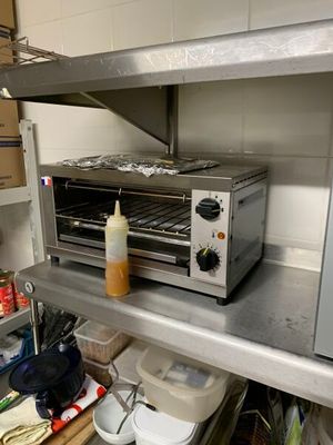 un four grille-pain posé sur une étagère dans une cuisine